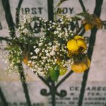 yellow rose on black metal frame leading to a gravestone